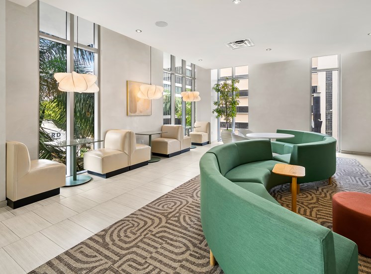 A waiting area with green chairs and a patterned carpet.